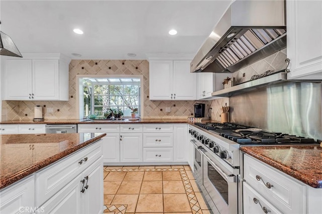 kitchen with stainless steel appliances, ventilation hood, sink, dark stone counters, and white cabinets