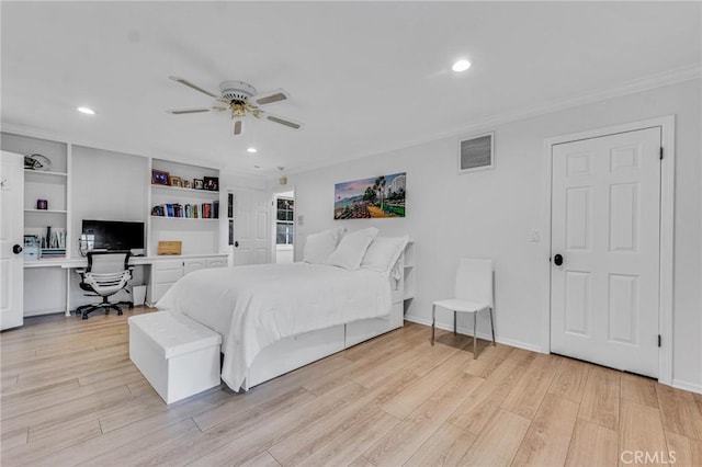 bedroom featuring ceiling fan, light wood-type flooring, crown molding, and built in desk