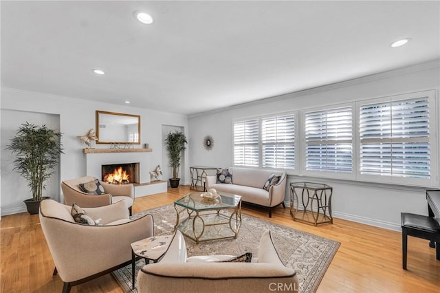 living room featuring light wood-type flooring and crown molding