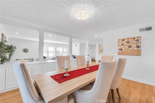 dining area featuring light wood-type flooring and ornamental molding