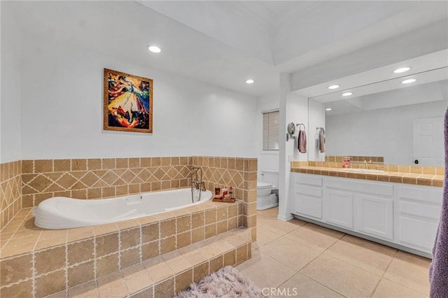 bathroom featuring tiled bath, tile patterned floors, vanity, and toilet