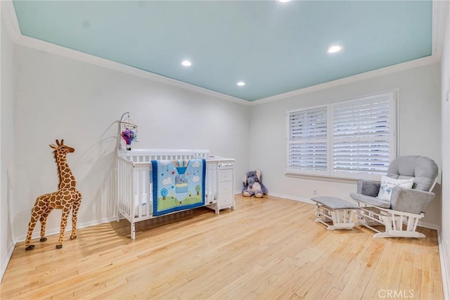 sitting room with crown molding and wood-type flooring