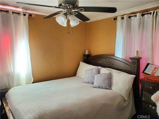 bedroom with ceiling fan and ornamental molding