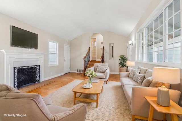 living room with vaulted ceiling and light hardwood / wood-style floors