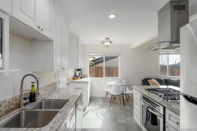 kitchen featuring light stone countertops, sink, white cabinets, and stainless steel appliances