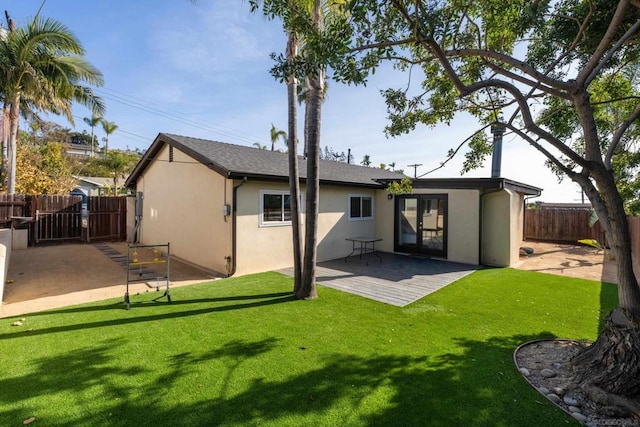 rear view of house featuring a yard and a patio