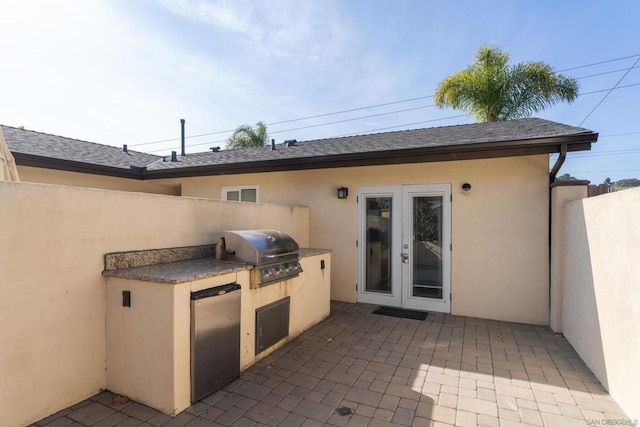 view of patio with french doors, an outdoor kitchen, and grilling area