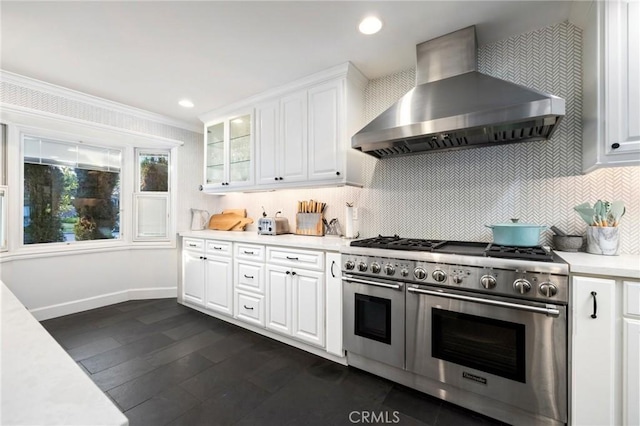 kitchen featuring exhaust hood, decorative backsplash, white cabinets, dark hardwood / wood-style floors, and range with two ovens