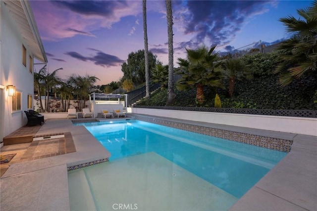 pool at dusk with a patio