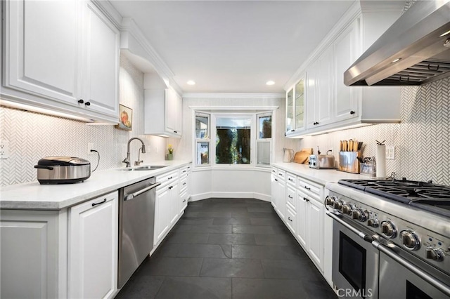 kitchen with wall chimney exhaust hood, backsplash, white cabinetry, and appliances with stainless steel finishes