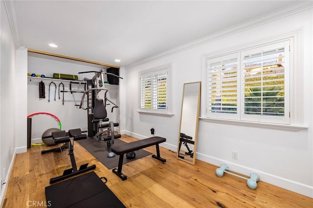 exercise area featuring hardwood / wood-style flooring and crown molding