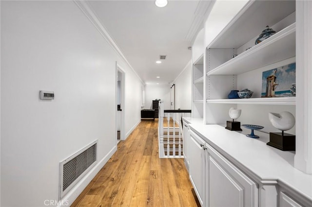 hall with crown molding and light wood-type flooring