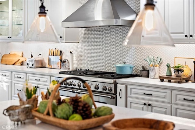 kitchen with white cabinetry, ventilation hood, double oven range, and backsplash