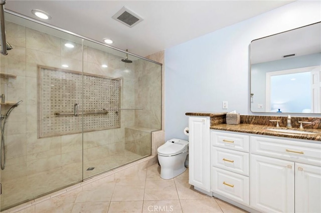 bathroom featuring tile patterned flooring, toilet, vanity, and walk in shower