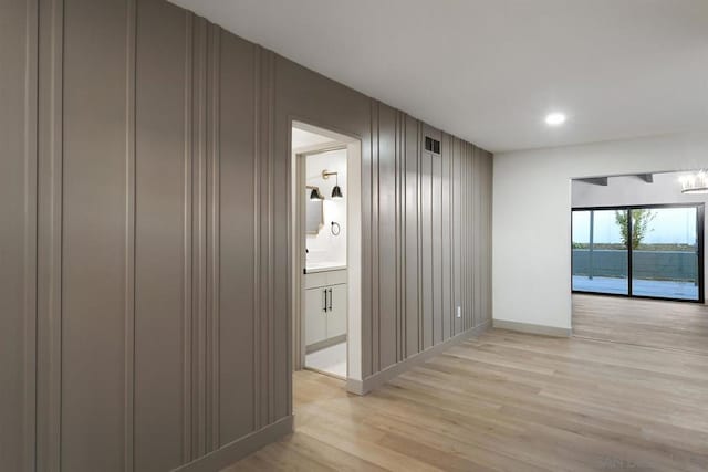 hall featuring wood walls and light wood-type flooring