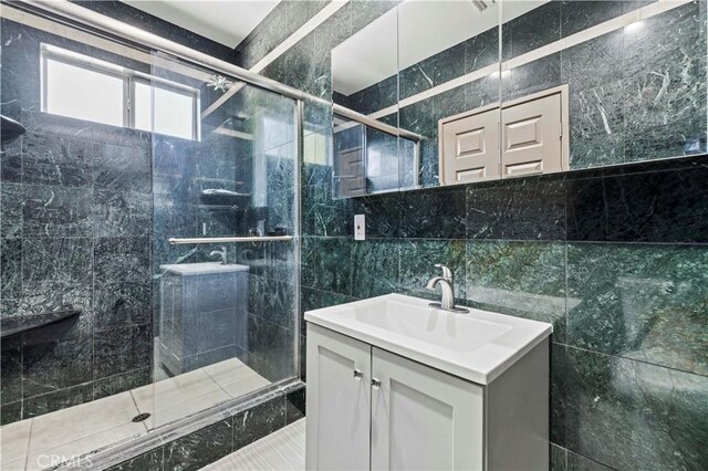 bathroom with vanity, walk in shower, and tile walls