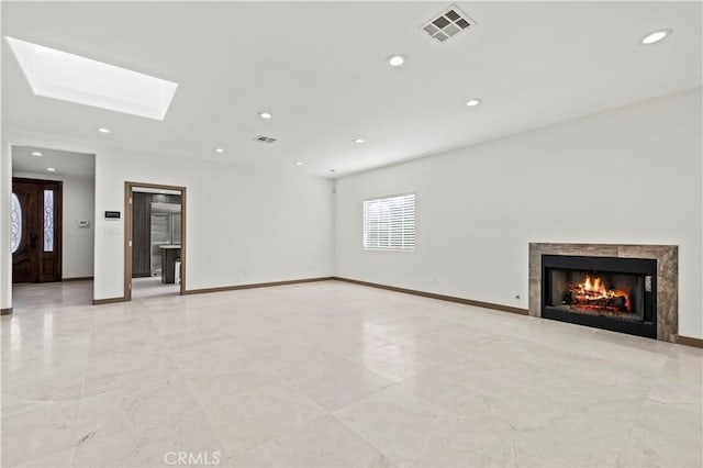 unfurnished living room with a skylight and a high end fireplace