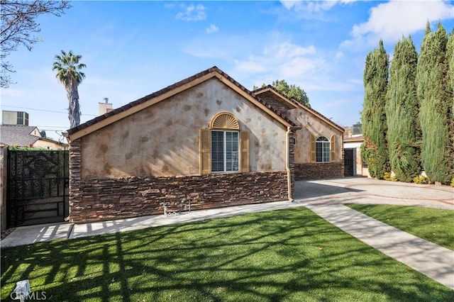 view of front of property with a front yard and central AC