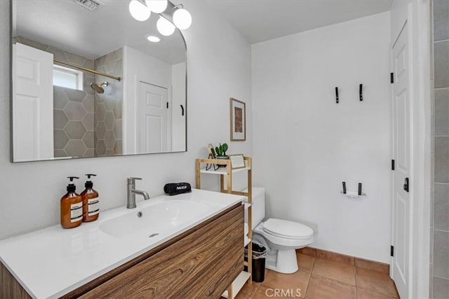 bathroom with toilet, walk in shower, vanity, and tile patterned flooring