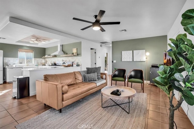 living room with sink, ceiling fan, light tile patterned floors, and a tray ceiling