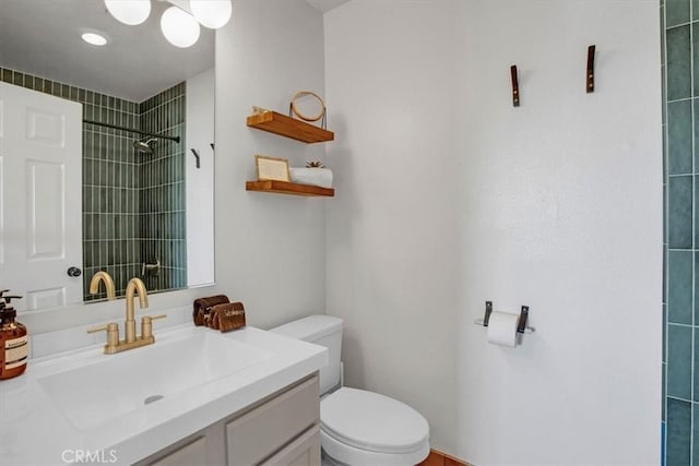 bathroom with tiled shower, toilet, and vanity