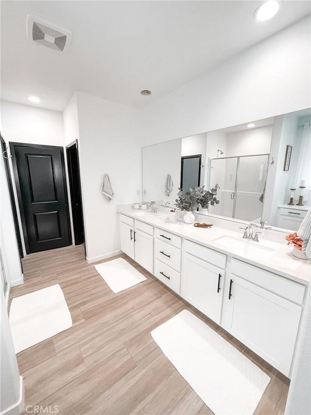 bathroom with an enclosed shower and vanity