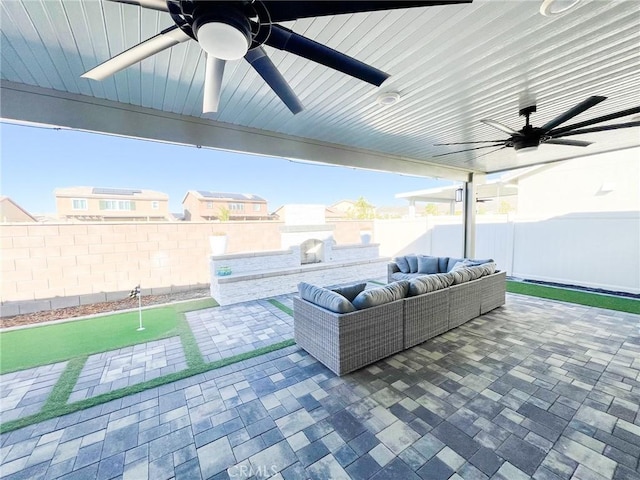 view of patio with an outdoor living space with a fireplace and ceiling fan