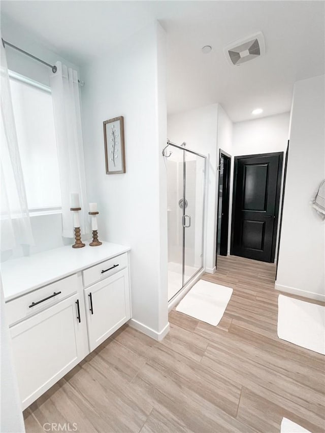 bathroom featuring vanity, hardwood / wood-style flooring, and an enclosed shower