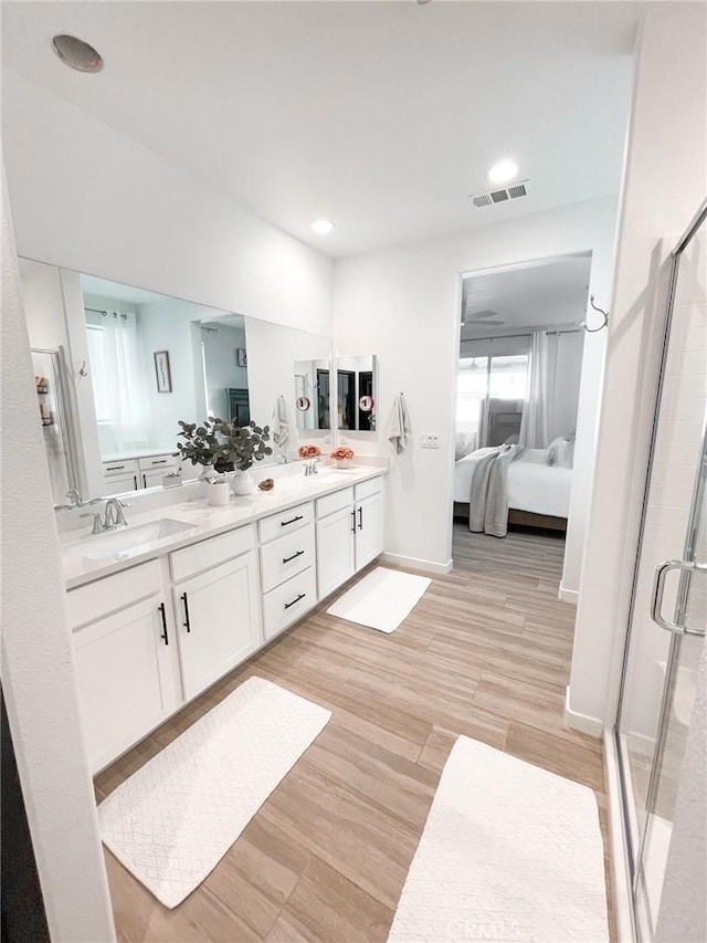 bathroom featuring a shower with shower door, hardwood / wood-style floors, and vanity