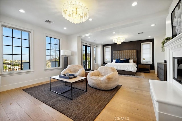 bedroom featuring light wood finished floors, visible vents, a chandelier, and baseboards