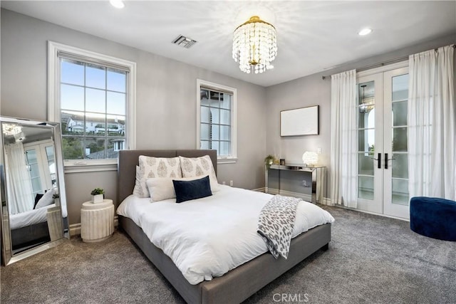 carpeted bedroom with a notable chandelier and french doors