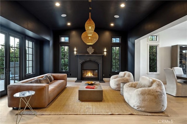 living area with recessed lighting, baseboards, wood finished floors, and a glass covered fireplace