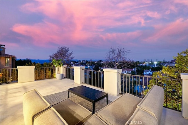 patio terrace at dusk featuring a balcony