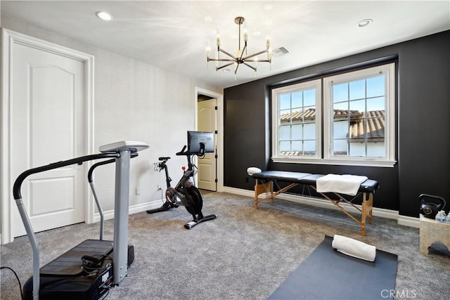 exercise area with a chandelier and carpet flooring