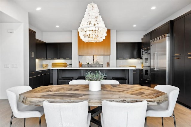 dining area with an inviting chandelier and light hardwood / wood-style floors