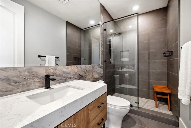 bathroom featuring vanity, tiled shower, tile patterned floors, and toilet