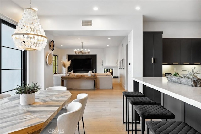 dining room with light hardwood / wood-style flooring and a chandelier