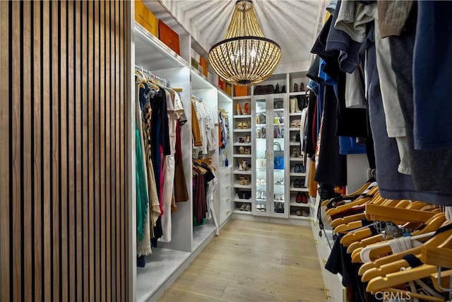 spacious closet with an inviting chandelier and light wood-type flooring