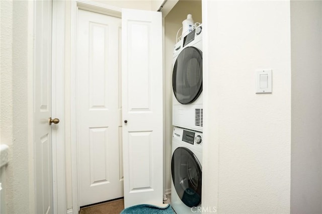 washroom with stacked washing maching and dryer