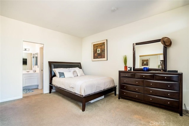 bedroom featuring light colored carpet and ensuite bathroom