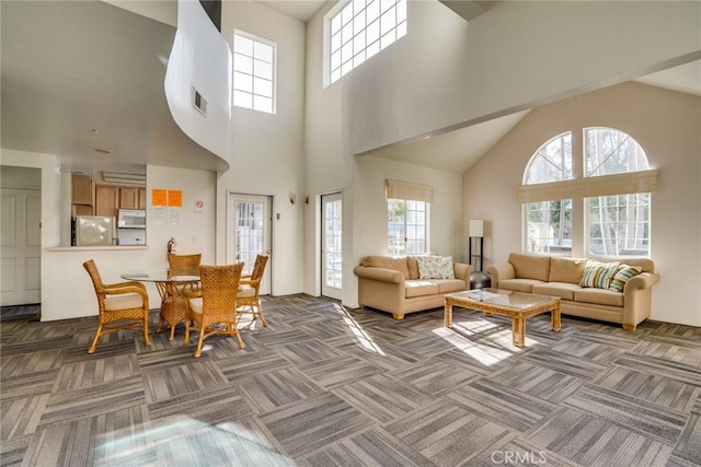 living room with a high ceiling and carpet floors