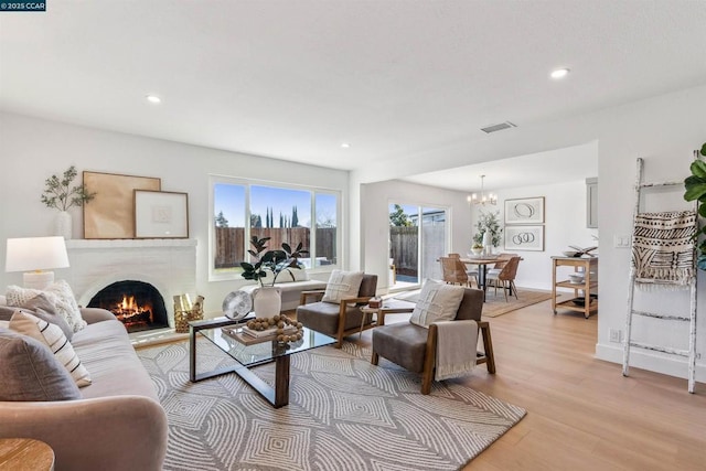 living room featuring light wood-type flooring and a notable chandelier