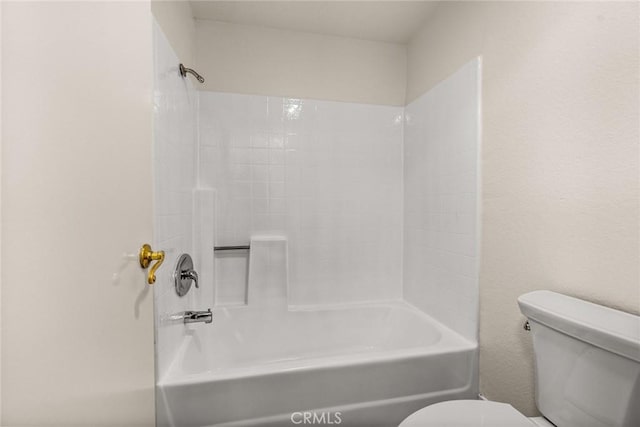 bathroom featuring tub / shower combination and toilet