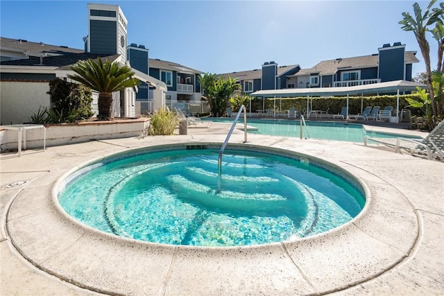 view of pool featuring a patio area and a hot tub