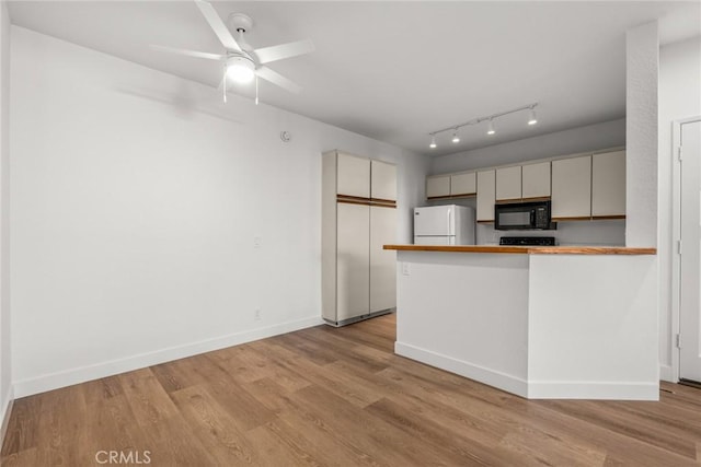 kitchen featuring kitchen peninsula, light hardwood / wood-style floors, ceiling fan, and white fridge