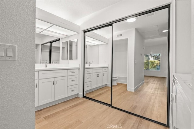 bathroom featuring hardwood / wood-style flooring, toilet, washer and clothes dryer, and vanity