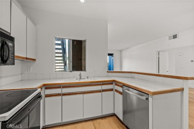 kitchen featuring kitchen peninsula, dishwasher, sink, white cabinets, and electric stove