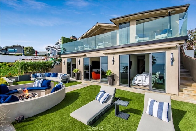 rear view of house featuring a patio area, a yard, and an outdoor living space with a fire pit