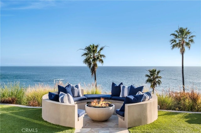 view of patio with an outdoor fire pit and a water view