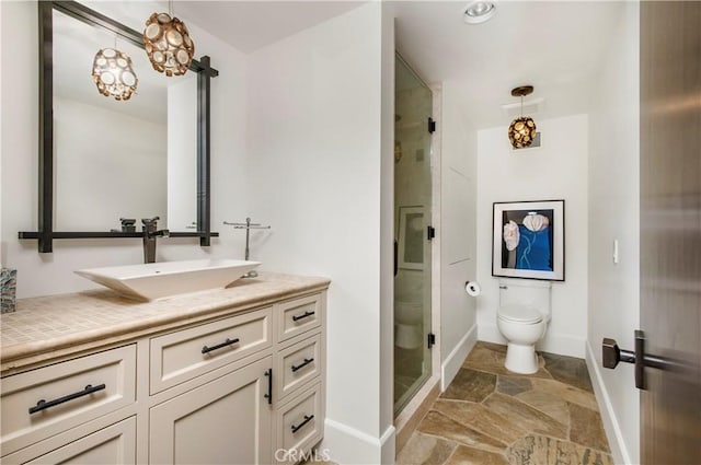 bathroom featuring toilet, an enclosed shower, and vanity